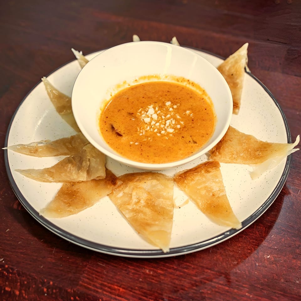 Ayuthaya Thai Cuisine's Roti Mataba, a crispy pancake dish with a side of yellow curry sauce.